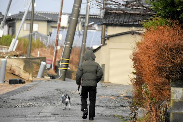 電柱が傾き、道路もでこぼこのままの西荒屋地区=2024年12月31日午後4時39分、石川県内灘町、土井良典撮影