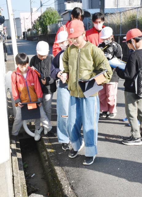 通路の危険箇所などを歩いて調査した西池小の児童ら