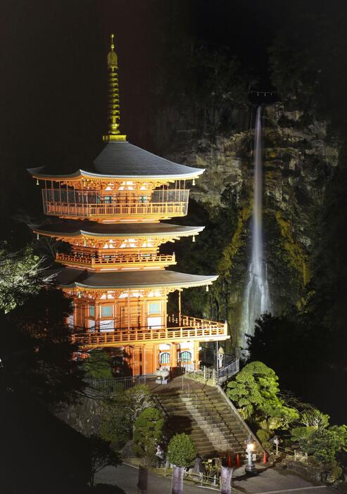 試験点灯が行われた「那智の滝」と青岸渡寺の「三重塔」＝19日夜、和歌山県那智勝浦町