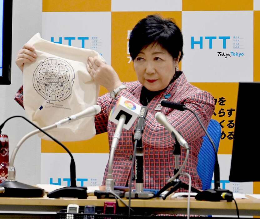 定例会見で受験生応援キャンペーンのトートバッグを手にする小池百合子知事＝13日（東京都提供）