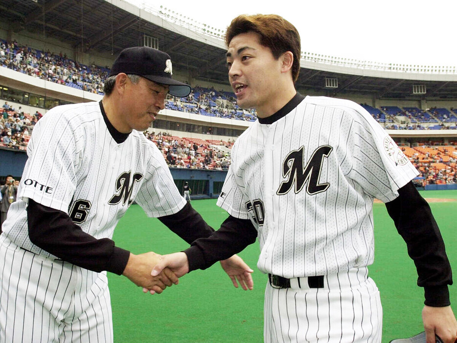 試合に勝利し、山本功児監督（写真左）と握手をする小林雅英　photo by Sankei Visual