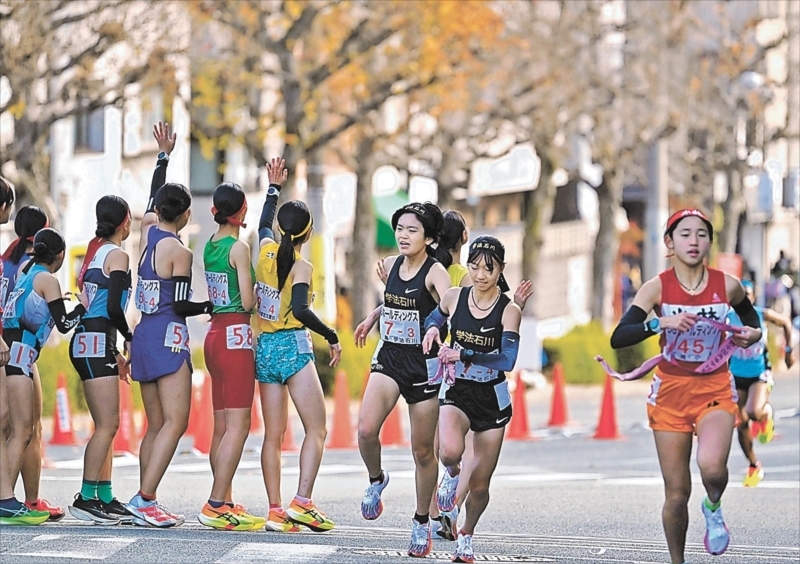 ３区金原選手からたすきを受け走り出す４区丹野選手（右から２人目）＝赤間陽菜撮影