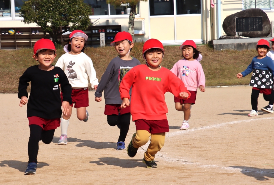 冬恒例のマラソン大会で元気な走りを披露する子どもたち。保護者や他学年からは、「がんばれー！」などの大声援が送られた＝2024年12月3日午前10時53分、兵庫県丹波篠山市内で