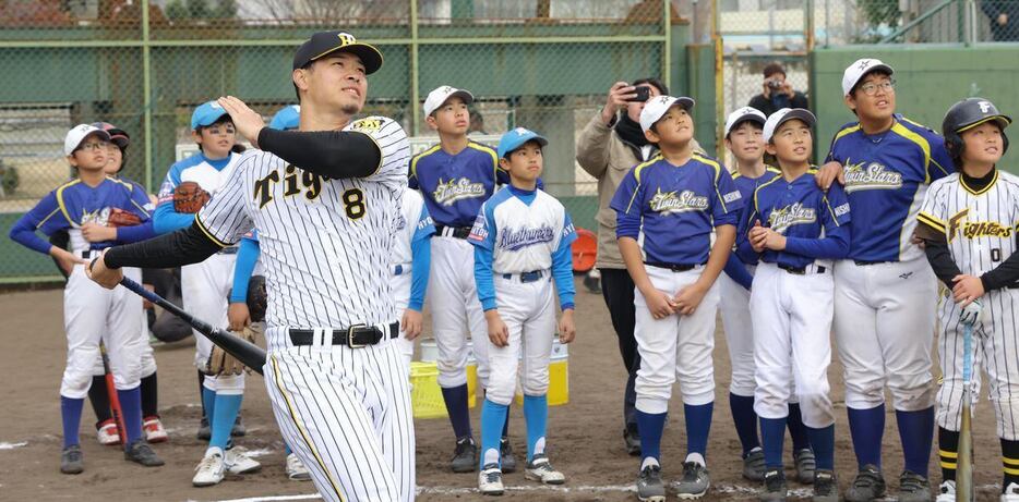 子どもたちにロングティーを披露する阪神・佐藤輝明＝津門中央公園野球場（撮影・水島啓輔)