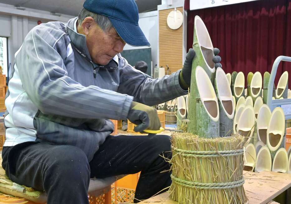 丁寧な作業でミニ門松を仕上げる町民＝１８日、さつま町の宮之城伝統工芸センター