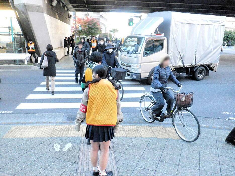 水引交差点で、黄色のベストを着て横断歩道の左側通行を呼びかける厚木高校の生徒＝厚木市水引