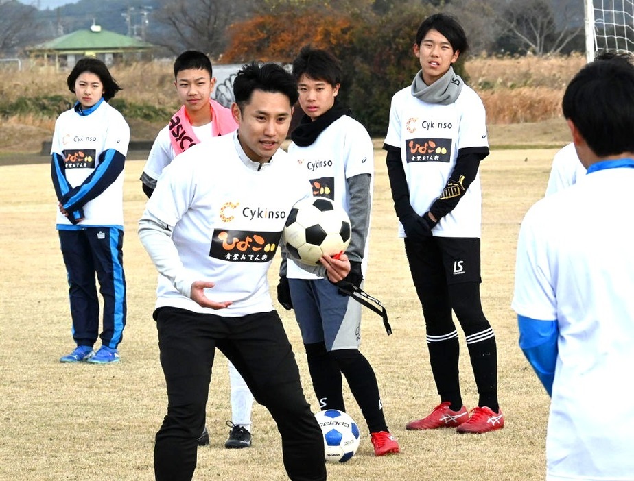 中学生に指導する森下選手（中央）＝袋井市愛野の原野谷川親水公園東側広場