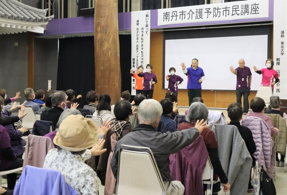 講師らの手本に合わせて体操をする「南丹市介護予防市民講座」の参加者たち（南丹市園部町・市国際交流会館）