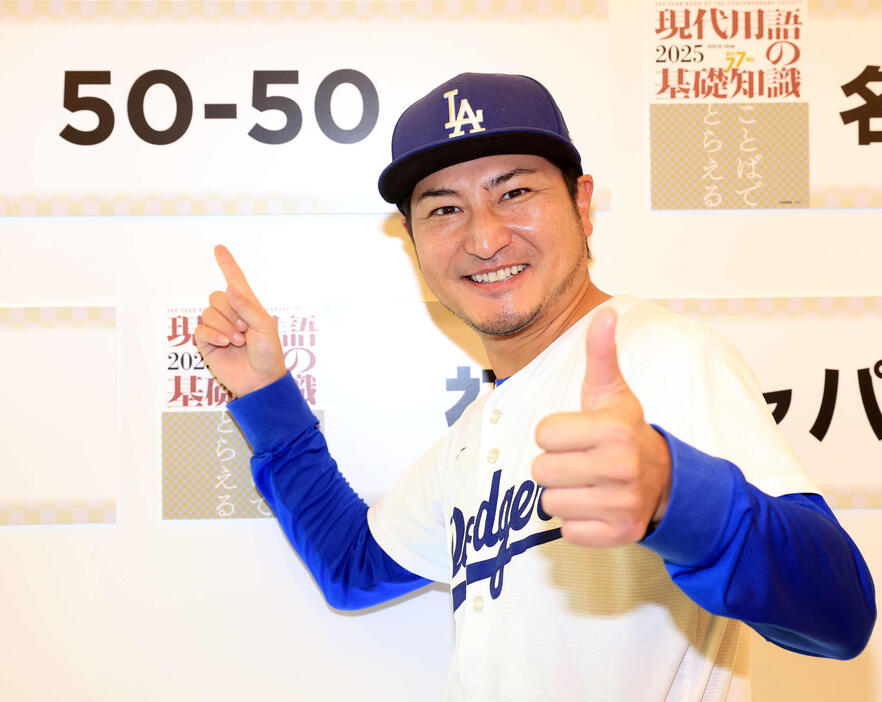 「2024ユーキャン新語・流行語大賞」表彰式　受賞した大谷翔平の「50－50」のボードの前で取材に訪れたミニタニはポーズ（撮影・浅見桂子）