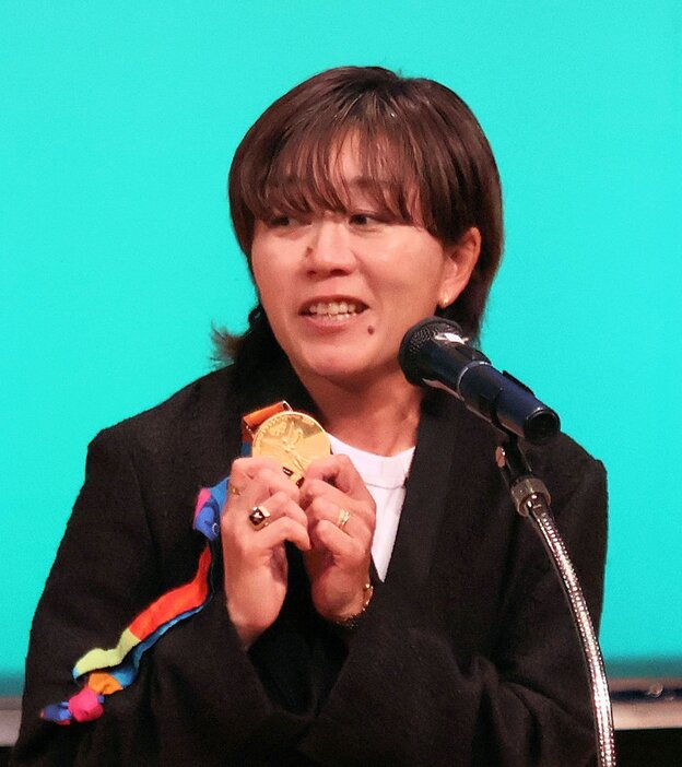 アテネ五輪の金メダルを手に高校生に語りかける野口さん（京都外大森田記念講堂）