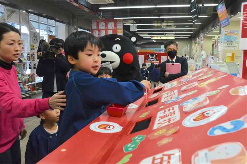 専用のポストに年賀状を投函する「認定こども園シオン」の園児たち＝16日、熊本市中央区