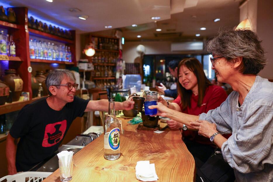 店主の長嶺哲成さん（左）と泡盛で乾杯する常連客ら＝５日午後６時37分、那覇市の「カラカラとちぶぐゎ～」（大城直也撮影）