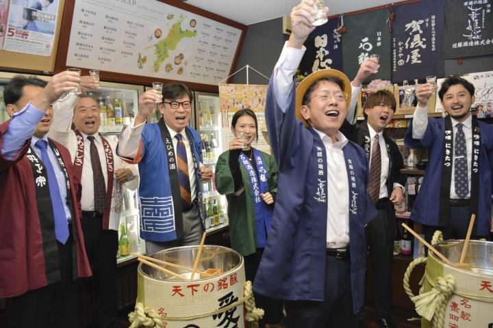 「伝統的酒造り」の無形文化遺産登録を祝って乾杯する県酒造組合の関係者ら＝5日夜、松山市一番町1丁目