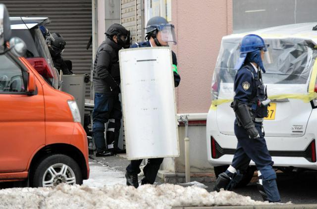 クマが居座っているとみられる建物周辺で警戒にあたる警察官ら=2024年12月26日午前10時34分、秋田市、滝沢隆史撮影