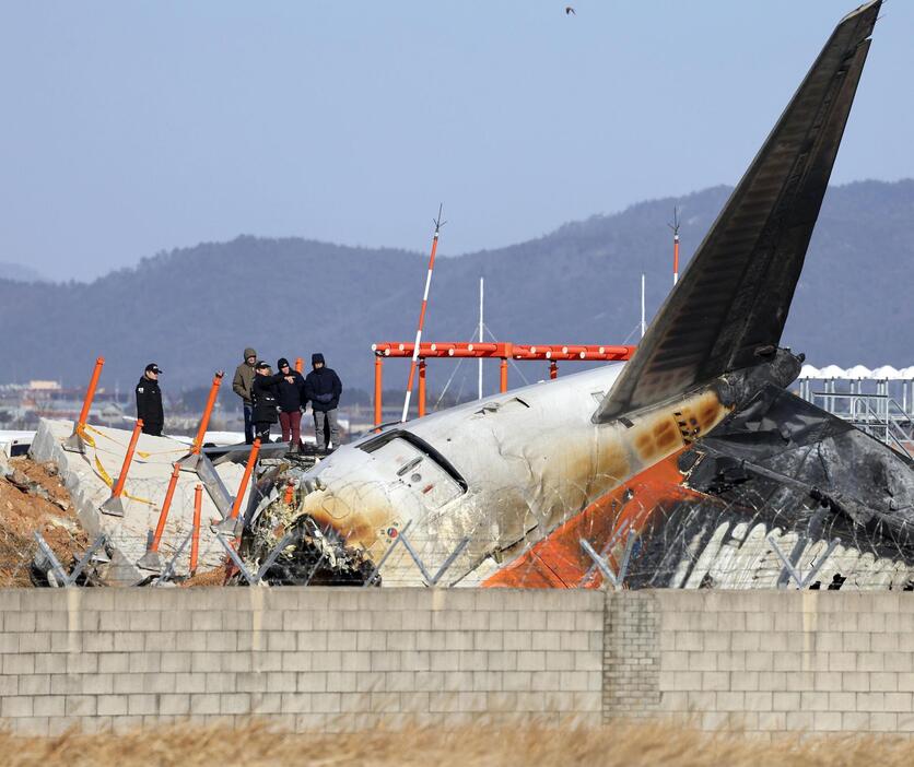 31日、韓国南西部の務安国際空港で事故機を調べる米国の運輸安全委員会の関係者ら（聯合＝共同）