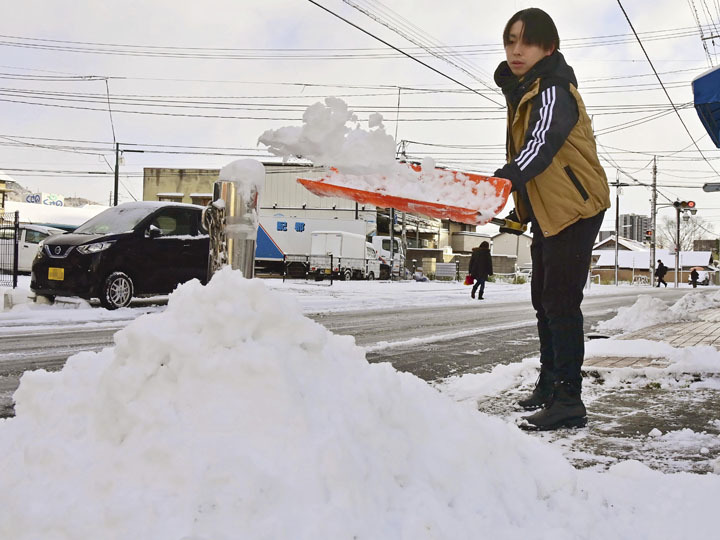 雪かきをする市民＝23日午前8時10分ごろ、福島市