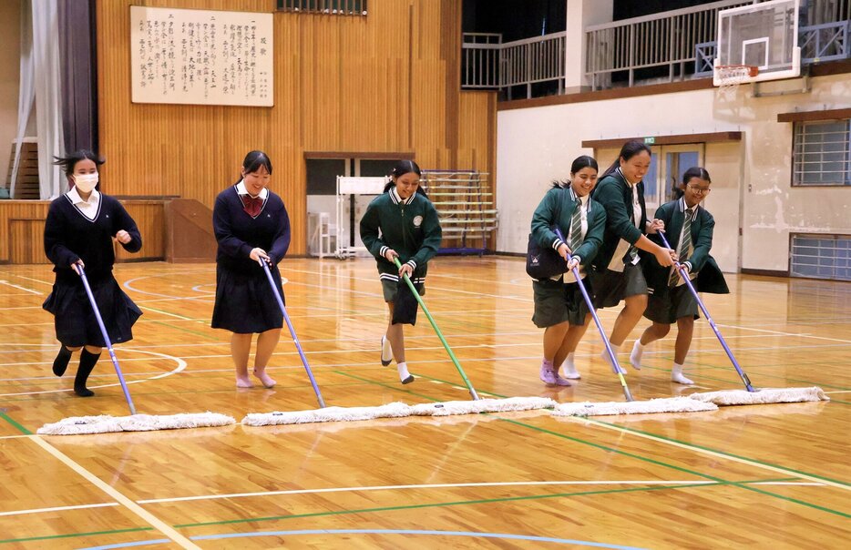 シンガポールから訪れた生徒たちと体育館の掃除をする西乙訓高の生徒ら（京都府長岡京市）