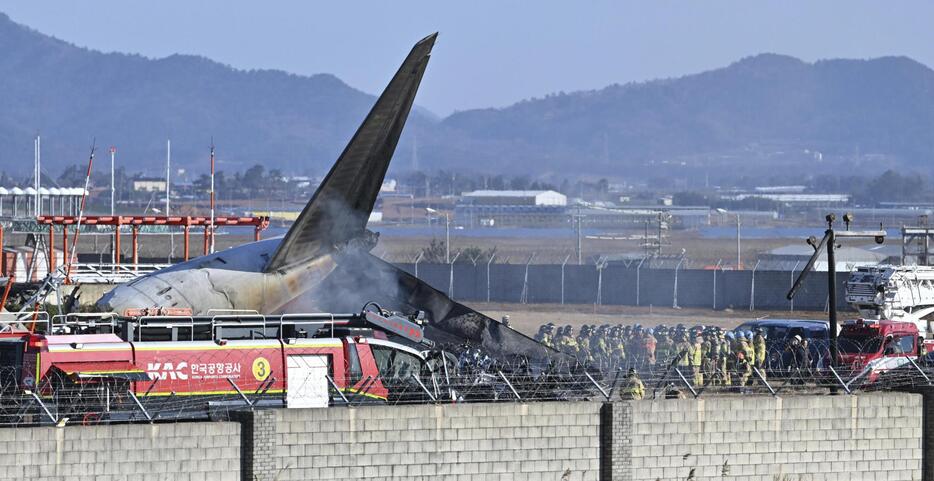 29日、旅客機事故が起きた韓国の務安国際空港で、救助に当たる消防隊員ら（AP＝共同）