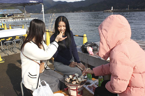 【ハマグリやイカを七輪で焼いて食べる観光客ら＝紀北町長島の長島港で】