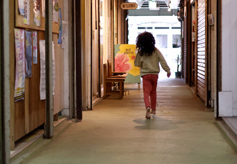 市場を裸足で歩き回る親富祖カナヨーちゃん（5）。母の愛さんが市場で店を営んでおり、カナヨーちゃんは幼い頃から市場で育った＝沖縄県本部町で2024年12月7日、喜屋武真之介撮影