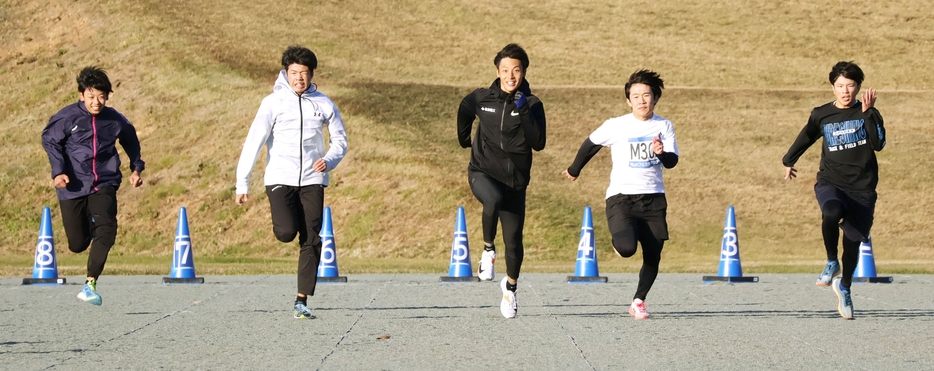 最後に中学3年男子と50㍍勝負する上山選手（真ん中）＝いずれも山下町の市総合運動公園芝生広場で