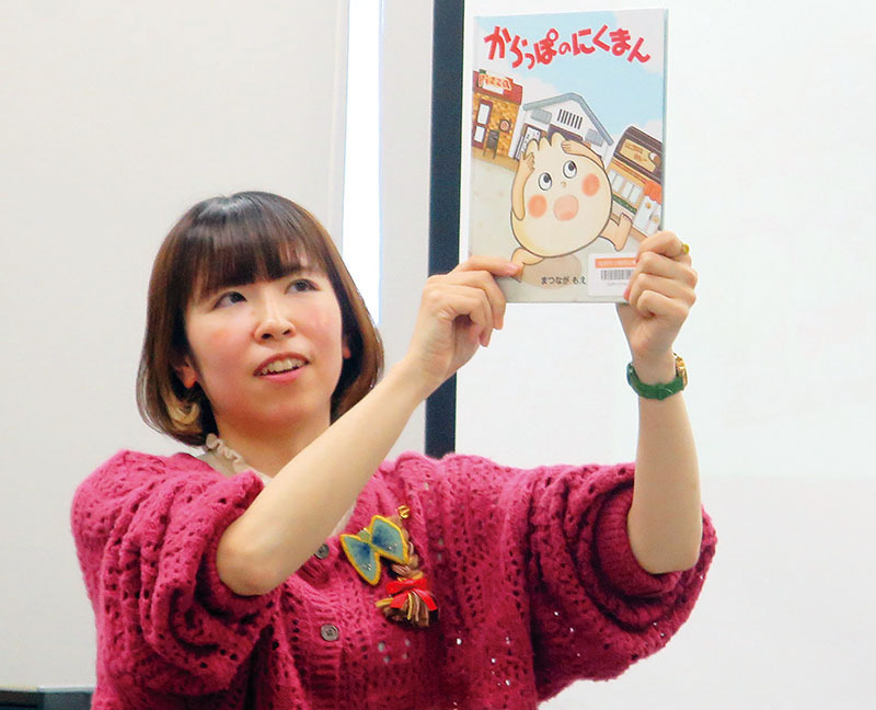 自身の作品「からっぽのにくまん」を紹介する絵本作家まつながもえさん＝23日午後、加須市中央の市民プラザかぞ1階視聴覚ホール