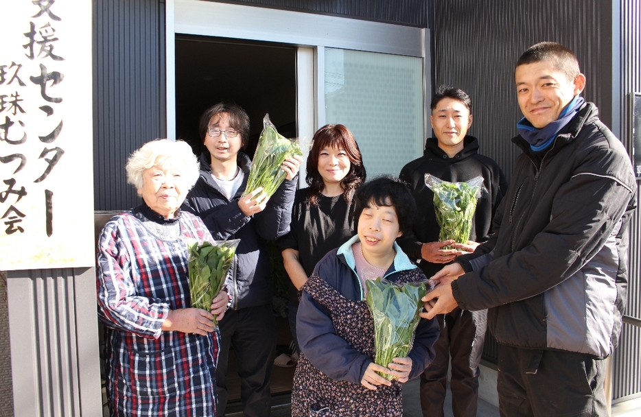 ホウレンソウの袋詰めを委託した川合誠大さん（右端）、岩村莉玖さん（右から2人目）と作業を請け負う玖珠むつみ会の利用者ら＝玖珠町帆足