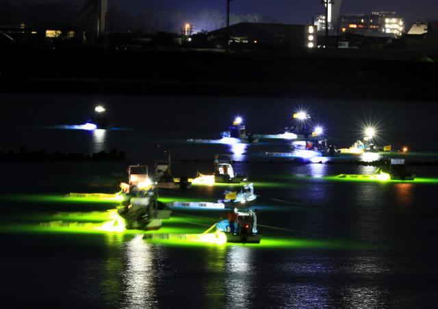 漁船の光が川面を照らし、幻想的な風景を作り出したシラスウナギ漁＝１０日午後１０時１５分、宮崎市の大淀川河口