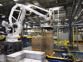 A robotic machine moves boxes of chocolate.