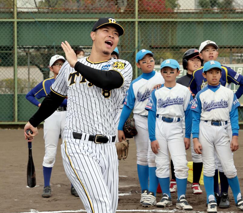 子供らの前で打撃のお手本を見せ、フルスイングする佐藤輝（撮影・田中太一）