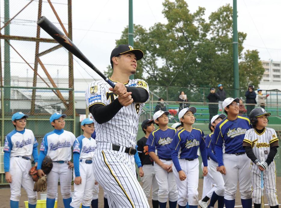 子どもたちにロングティーを披露する阪神・佐藤輝明＝津門中央公園野球場（撮影・水島啓輔)