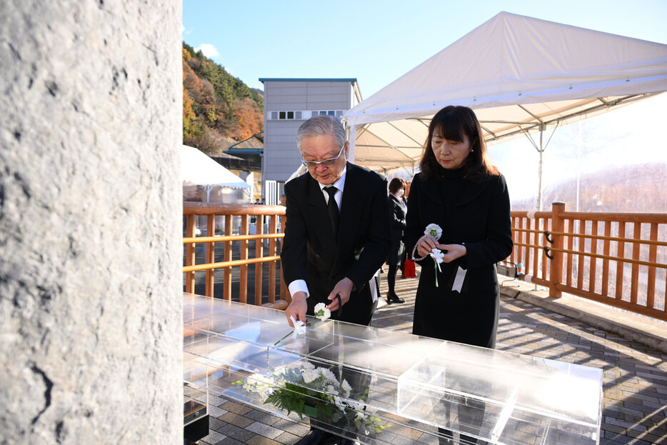 笹子トンネル事故から１２年を迎え、慰霊碑に献花する遺族ら＝２日午前、山梨県大月市（代表撮影）