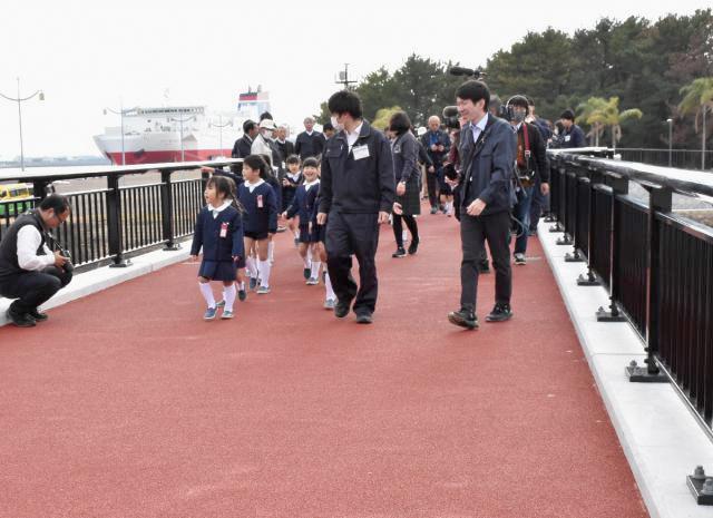 「りんかいひなた橋」の利用開始を祝って渡り初めする園児ら＝１７日午後、宮崎市