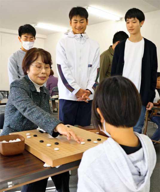 幼い時から通う子どもたちに囲まれて碁を打つ杉山聡子さん（左）＝宮崎市・日本棋院宮崎支部