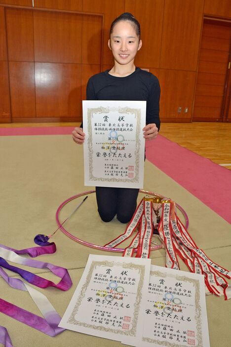 賞状やトロフィーに囲まれる柳澤さん