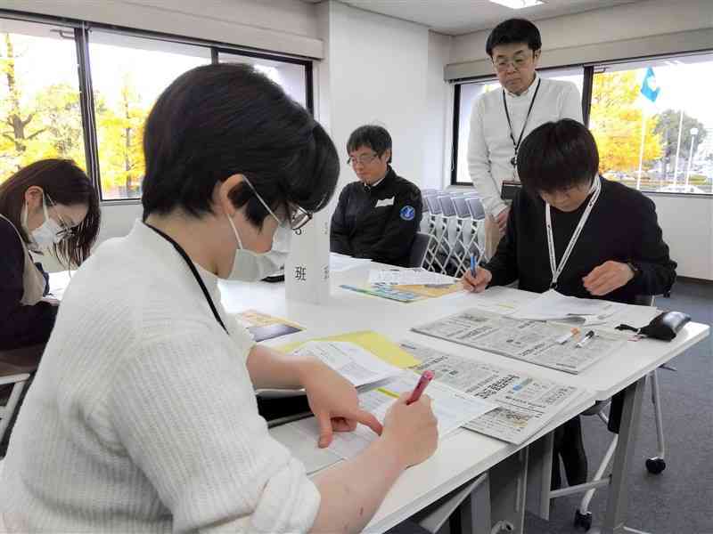 新聞記事を参考に簡潔なビジネス文書の書き方を学ぶ県立大の若手職員＝13日、熊本市東区