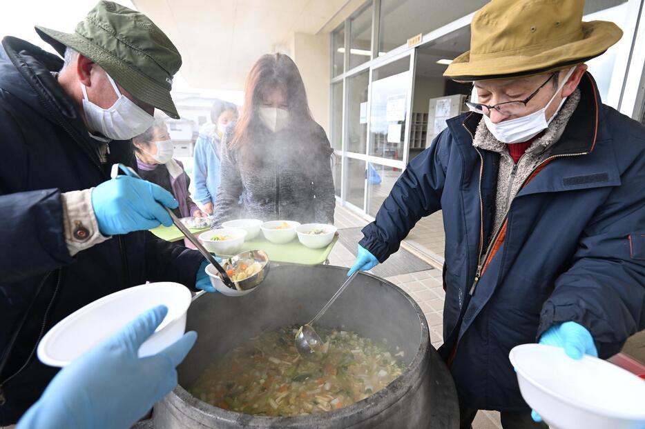 避難所で炊き出しの豚汁を配る富山県のボランティア団体＝石川県能登町立小木中学校で2024年1月15日、北山夏帆撮影