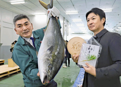 最高級のブリを競り落とした「どんたく」の山口社長（右）（２日午前８時２０分、金沢市で）＝宮本悠希撮影