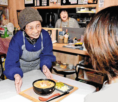 喫茶店で接客する敏子さん（左）と経営者の藤原さん（中央奥）（11月22日、東京都千代田区で）