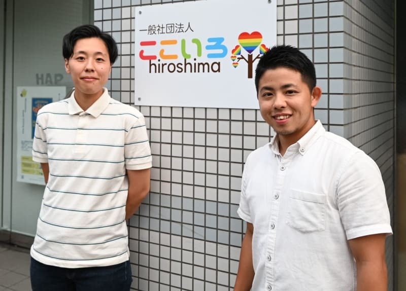 「ここいろhiroshima」の事務所前に立つ高畑桜さん（左）と當山敦己さん＝２０２４年９月、広島市