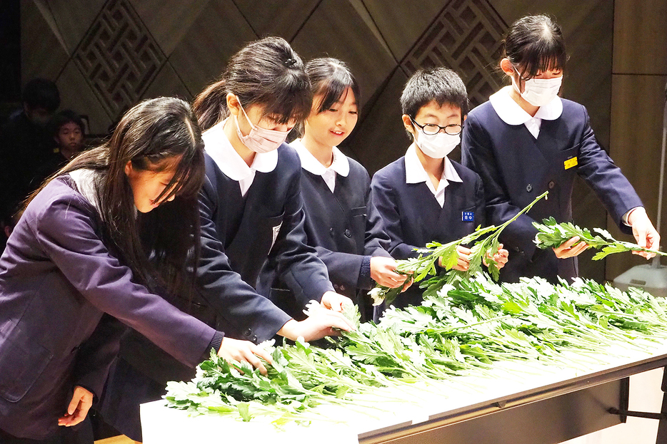 先人の偉業をたたえ、花を手向ける出席者たち