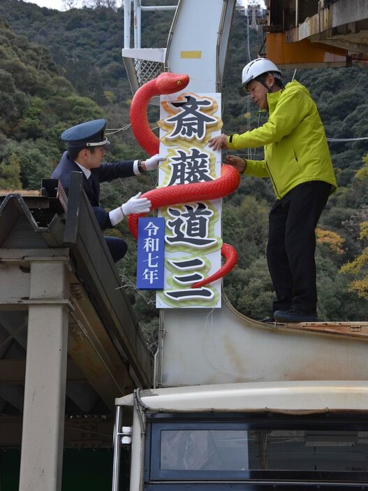 巳年にちなみ、マムシをあしらった飾りを取りつける職員＝岐阜市千畳敷下、ぎふ金華山ロープウェー山麓駅