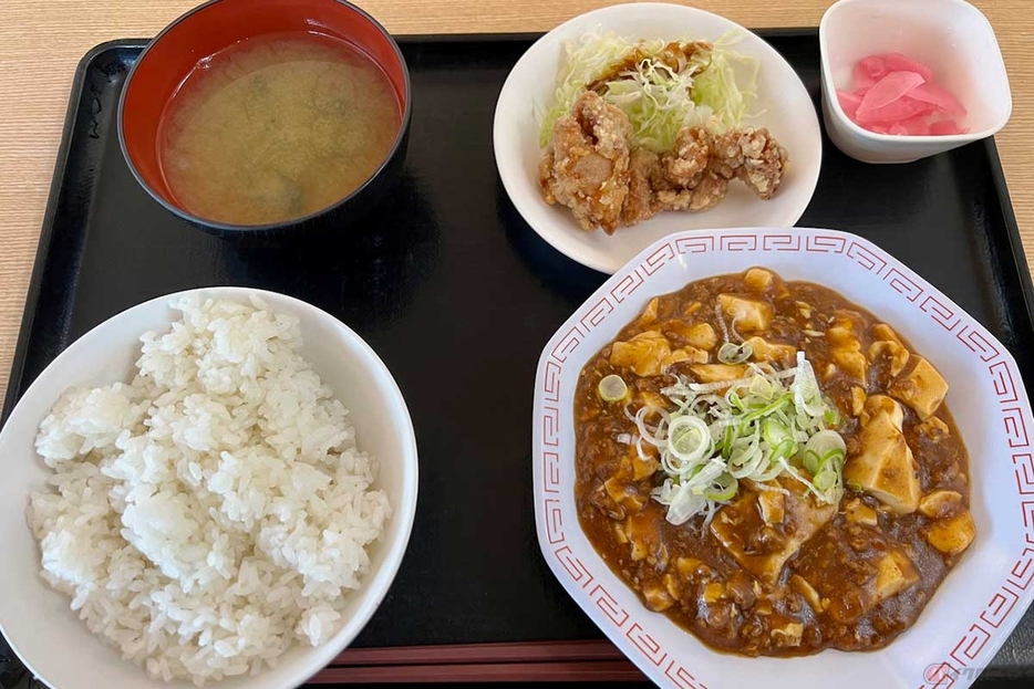 東名高速「鮎沢PA」（下り）でいただく「マーボー定食」（890円）は、四川風とは異なり辛さの少ない、昔ながらのまろやかな味わい。ご飯がバクバク進む、懐かしい食堂の味。漬物はセルフサービス。ライスと味噌汁はおかわり自由