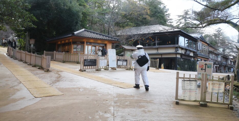 イノシシが目撃された兼六園桂坂口周辺をパトロールする警察官＝１２日午前１０時５分