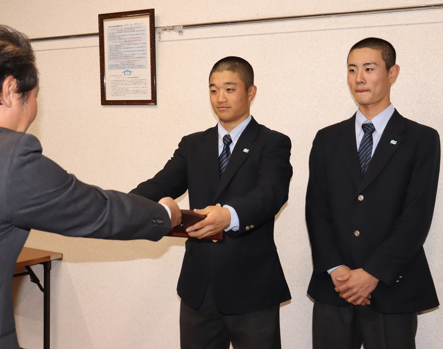 毎日新聞横浜支局の高山祐支局長から表彰盾を受け取る山本康太主将（左）と内藤大維マネジャー＝横浜市南区の横浜清陵高校で２０２４年１２月１９日、宮本麻由撮影