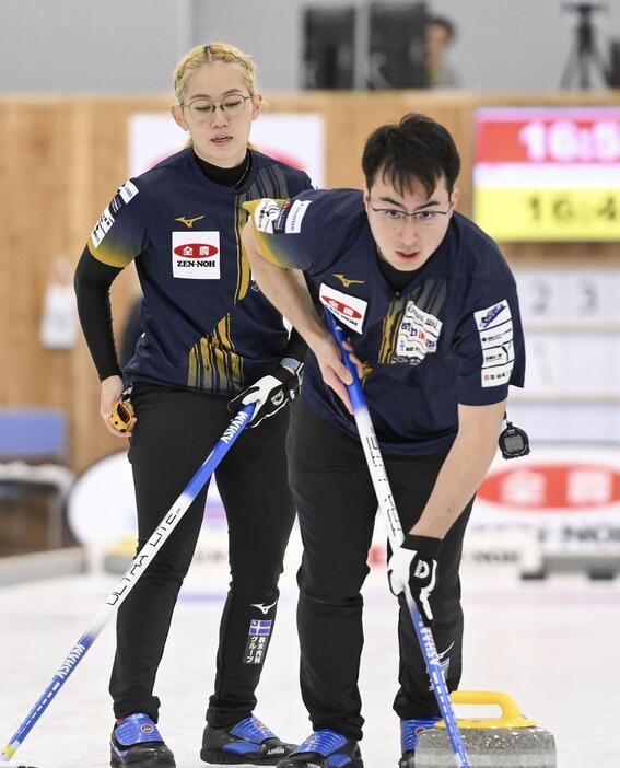 カーリングの日本混合ダブルス選手権2次リーグでプレーする小穴桃里（左）、青木豪組＝稚内市みどりスポーツパーク（（C）JCA/H.IDE）