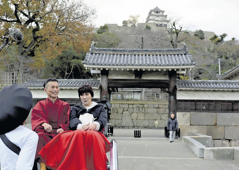 大手二の門前で城の説明を受ける三嶌さん夫婦（香川県丸亀市で）