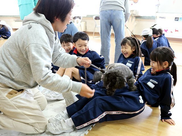 児童の膝の上に乗る犬