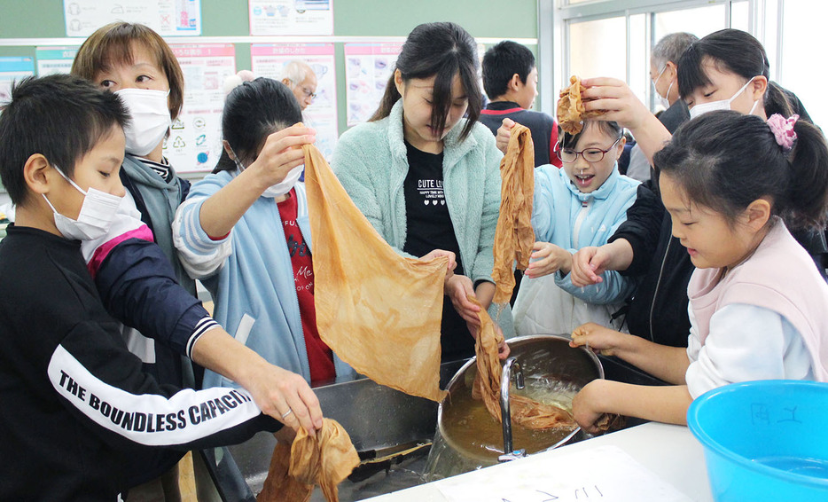 自然の素材を使って染色体験をする子供たち＝大台町佐原の三瀬谷小で