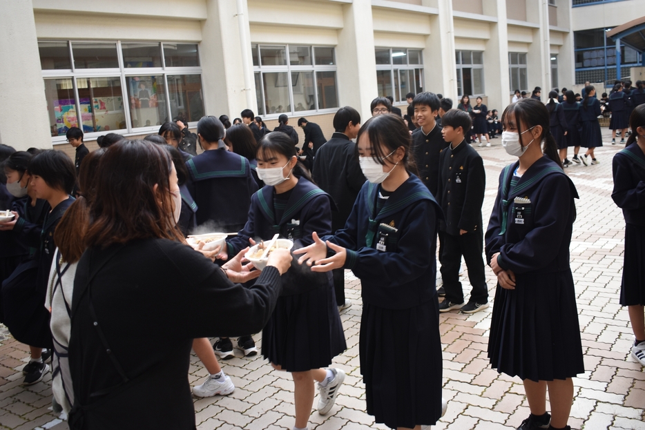 特製のしし鍋を受け取る生徒たち=岡山県美作市で